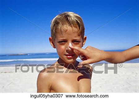 Stock Photo - Portrait of a boy standing on the beach. Fotosearch