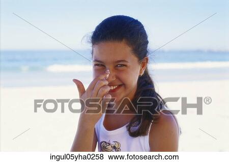 Portrait of a girl applying cream on her face View Large Photo Image Stock Photo - Portrait of a girl applying cream on her face. Fotosearch