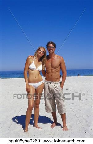 Portrait of a young couple standing on the beach View Large Photo Image Stock Photo - Portrait of a young couple standing on the beach. Fotosearch