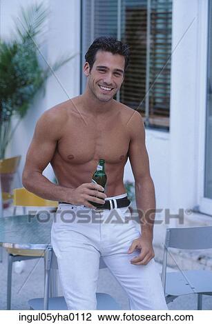 Portrait of a young man holding a bottle View Large Photo Image Stock Image - Portrait of a young man holding a bottle. Fotosearch
