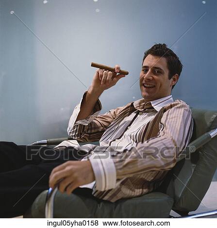 Stock Photo - Portrait of a young man holding a cigar. Fotosearch