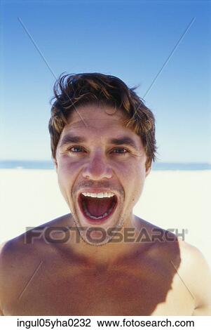Stock Image - Portrait of a young man with his mouth wide open. Fotosearch
