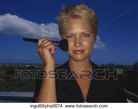 Portrait of a young woman applying blush View Large Photo Image Picture - Portrait of a young woman applying blush. Fotosearch