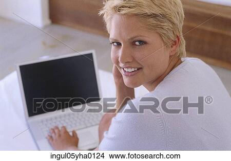 Portrait of a young woman working on a laptop View Large Photo Image Picture - Portrait of a young woman working on a laptop. Fotosearch