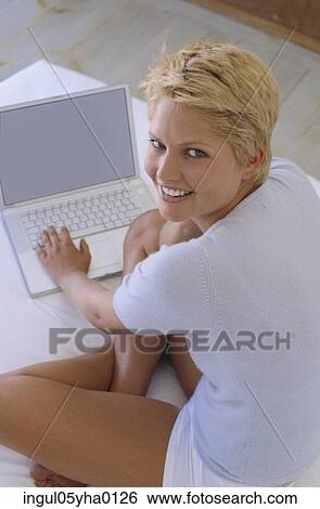 Stock Photograph - Portrait of a young woman working on a laptop. Fotosearch