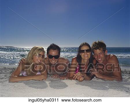 Portrait of two young couples lying down on the beach View Large Photo Image Stock Image - Portrait of two young couples lying down on the beach. Fotosearch