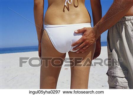 Stock Photo - Rear view of a young man touching a young woman's bottom. Fotosearch
