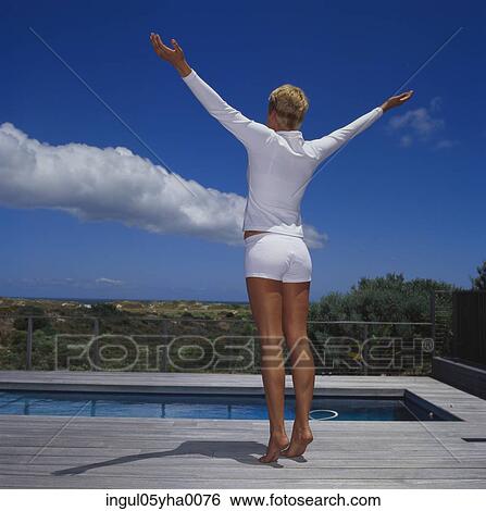 Rear view of a young woman with her arms stretched out View Large Photo Image Stock Photograph - Rear view of a young woman with her arms stretched out. Fotosearch