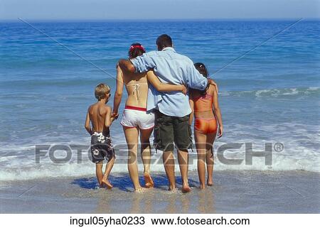 Rear view of parents and their son and daughter on the beach View Large Photo Image Stock Image - Rear view of parents and their son and daughter on the beach. Fotosearch