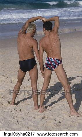 Rear view of two mid adult men on the beach View Large Photo Image Stock Photo - Rear view of two mid adult men on the beach. Fotosearch