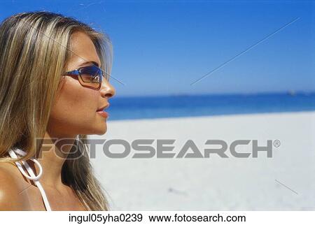 Stock Photo - Side profile of a young woman on the beach. Fotosearch