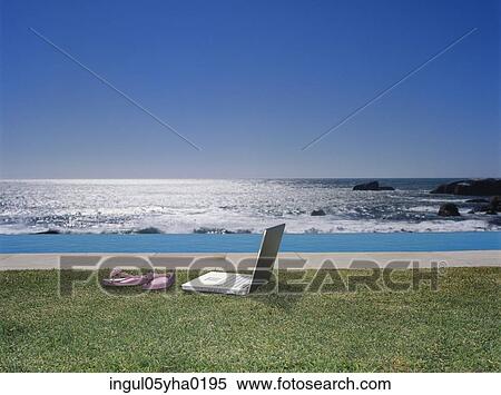 Stock Photography - Slippers and a laptop on a lawn. Fotosearch