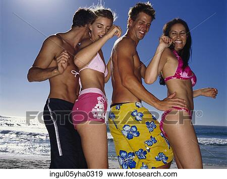 Stock Photo - Two young couples dancing on the beach. Fotosearch