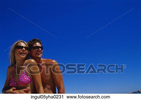 Stock Image - Young couple holding each other on the beach. Fotosearch