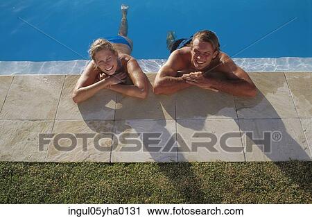 Young couple lying beside a swimming pool View Large Photo Image Stock Image - Young couple lying beside a swimming pool. Fotosearch