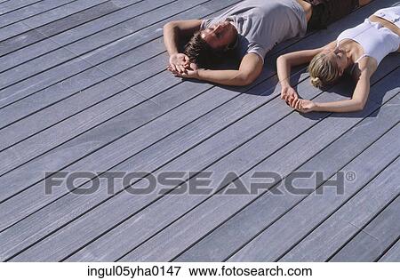 Young couple lying down on the floor View Large Photo Image Stock Photo - Young couple lying down on the floor. Fotosearch