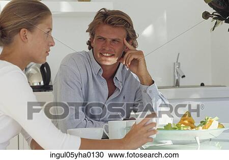 Young couple sitting at a table View Large Photo Image Stock Image - Young couple sitting at a table. Fotosearch