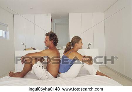 Young couple sitting back to back View Large Photo Image Stock Photo - Young couple sitting back to back. Fotosearch