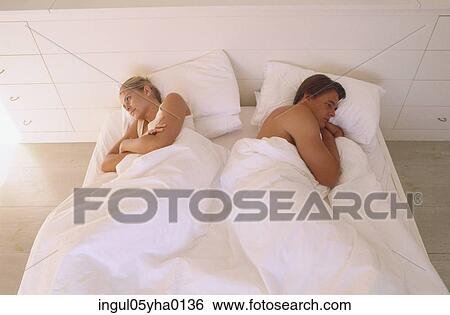 Young couple sleeping on a bed View Large Photo Image Stock Photograph - Young couple sleeping on a bed. Fotosearch
