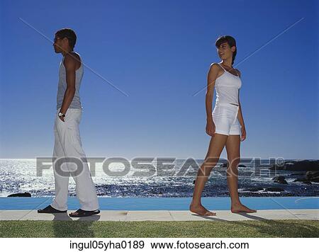 Young couple standing back to back View Large Photo Image Stock Photo - Young couple standing back to back. Fotosearch