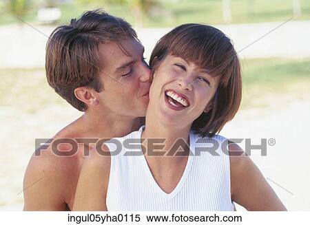 Stock Photography - Young ma kissing a young woman. Fotosearch
