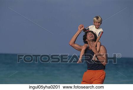 Young man carrying a boy on his shoulders on the beach View Large Photo Image Stock Image - Young man carrying a boy on his shoulders on the beach. Fotosearch