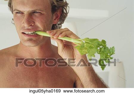 Stock Photo - Young man eating lettuce. Fotosearch
