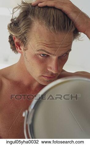 Young man looking into a mirror View Large Photo Image Stock Image - Young man looking into a mirror. Fotosearch