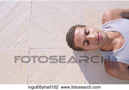 Young man lying down View Large Photo Image Stock Image - Young man lying down. Fotosearch