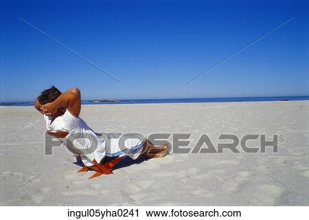 Young man sitting on a chair on the beach View Large Photo Image Stock Image - Young man sitting on a chair on the beach. Fotosearch