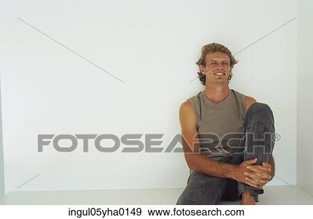 Young man sitting on the floor View Large Photo Image Stock Photo - Young man sitting on the floor. Fotosearch