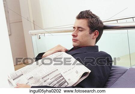 Stock Image - Young man sleeping with a newspaper. Fotosearch