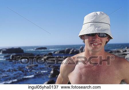 Young man standing on the beach View Large Photo Image Stock Photo - Young man standing on the beach. Fotosearch