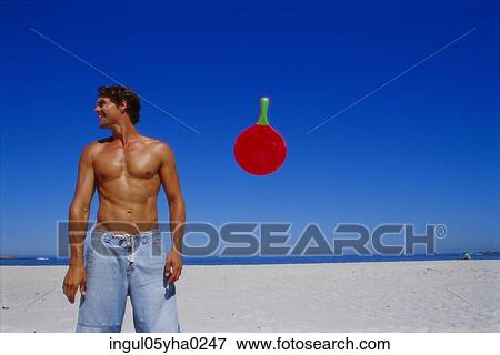 Young man standing on the beach View Large Photo Image Stock Photo - Young man standing on the beach. Fotosearch