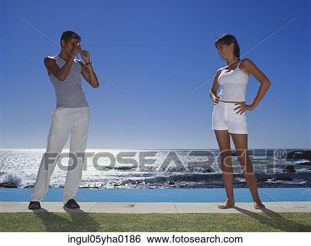 Stock Photograph - Young man taking a photograph of a young woman. Fotosearch