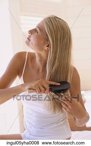 Young woman brushing her hair View Large Photo Image Stock Photo - Young woman brushing her hair. Fotosearch