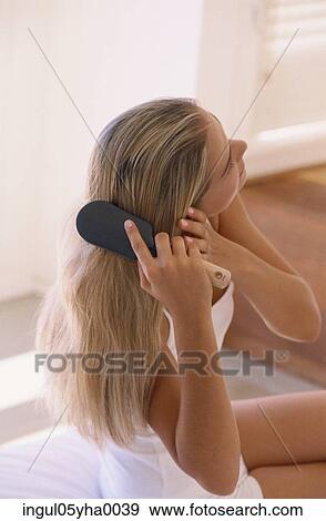 Young woman brushing her hair View Large Photo Image Stock Photo - Young woman brushing her hair. Fotosearch