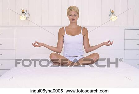 Young woman doing yoga on a bed View Large Photo Image Stock Photography - Young woman doing yoga on a bed. Fotosearch