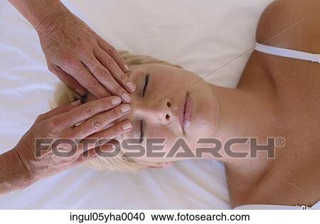 Stock Image - Young woman getting a head massage. Fotosearch