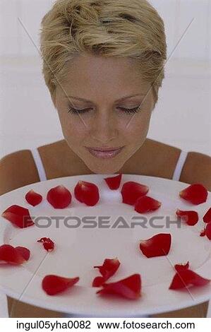 Young woman holding a plate with rose petals View Large Photo Image Stock Image - Young woman holding a plate with rose petals. Fotosearch