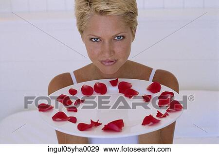 Young woman holding a plate with rose petals View Large Photo Image Stock Photo - Young woman holding a plate with rose petals. Fotosearch