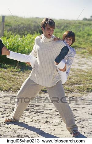 Young woman riding piggyback on a young man View Large Photo Image Stock Image - Young woman riding piggyback on a young man. Fotosearch