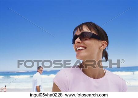 Young woman standing on the beach View Large Photo Image Stock Photo - Young woman standing on the beach. Fotosearch