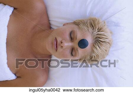 Young woman with a therapeutic stone on her forehead View Large Photo Image Stock Image - Young woman with a therapeutic stone on her forehead. Fotosearch