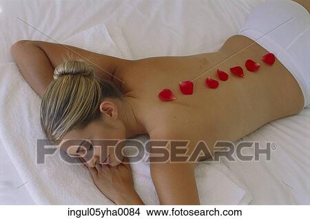 Picture - Young woman with rose petals on her back. Fotosearch
