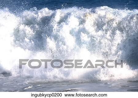 Stock Image - Large wave crashing in the sea. Fotosearch
