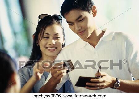 Stock Photograph - men, women, finance, paying, shop, looking down, clothing. Fotosearch