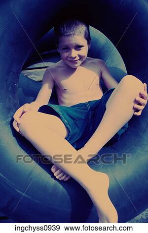 Stock Photo - people, water, smiling, sitting, inner tube, boy, outdoors. Fotosearch