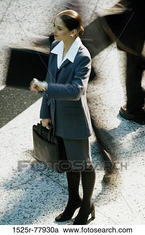 Stock Image - blur, woman, briefcase, motion, business, outdoors, checking. Fotosearch