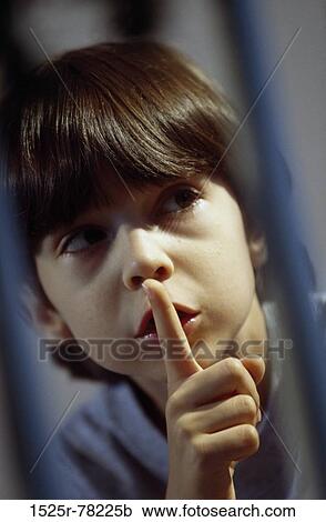 Boy with his finger on his lip View Large Photo Image Stock Image - Boy with his finger on his lip. Fotosearch